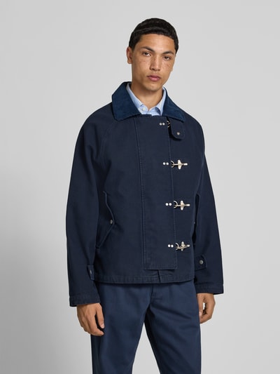 Männermodel trägt Regular Fit Jacke mit Umlegekragen von Forét, Reine Baumwolle, Verschlussschnallen, Eingrifftaschen, Ganzkörperansicht von vorne.