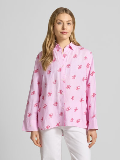 Frauenmodel trägt Oversized Hemdbluse aus Leinen-Viskose-Mix von Tommy Hilfiger, Optik:Allover-Muster, Gestreift, Logo-Stitching, Kragenform: Hemdblusenkragen, Passform: Oversized, Verschluss: Knopfleiste, Langarm mit Manschette, Rumpfabschluss: Abgerundet, Asymmetrisch, in Rosa und Weiß mit leichter Struktur. Ganzkörperansicht von vorne.