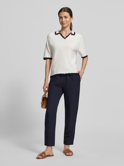 Modelka nosi Straight Fit Stoffhose aus Viskose-Mix mit Leinen-Anteil von Marc Cain, ciemnogranatowy materiał stylizowany na len, wpuszczane kieszenie, elastyczny pas z tunelem, szerokość w rozmiarze 36: 37 cm, długość wewnętrzna nogawki w rozmiarze 36: 66 cm, widok całej sylwetki z przodu.