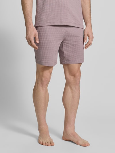 Mężczyzna nosi Regular Fit Sweatshorts aus Baumwoll-Mix Modell 'AUSTIN' od HUGO, kolor jednolity, wafel struktura, krój regular fit, bawełniany materiał, widok z przodu na całe ciało.