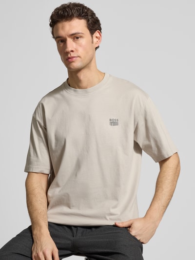 Mężczyznamodel nosi Regular Fit T-Shirt aus reiner Baumwolle Modell 'TE-BRUTALISM' von BOSS Orange w jednolitym kolorze, okrągły dekolt, krótki rękaw, materiał bawełna z delikatnym żebrowaniem, widoczna aplikacja z logo, zdjęcie: zbliżenie na górną część ciała.