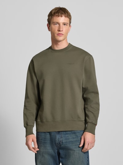 Männermodel trägt Sweatshirt mit Rundhalsausschnitt und Label-Stitching von Levi's®, olivgrün, Baumwolle, Regular Fit, Nahaufnahme Oberkörper.
