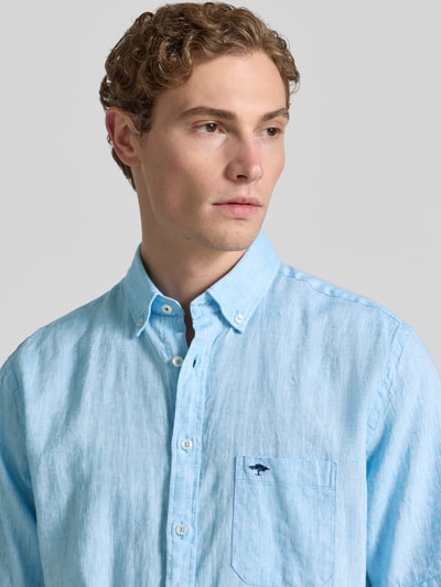 Männermodel draagt Slim Fit Freizeithemd aus Leinen-Baumwoll-Mix van Fynch-Hatton in lichtblauw met borstzak, button-downkraag, labelstitching, knoopsluiting, mix van linnen en katoen, ruglengte maat M 74 cm, schouderbreedte 48 cm, mouwlengte 26 cm, Nahaufnahme Oberkörper.
