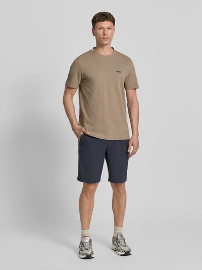 Männermodel trägt Regular Fit T-Shirt aus Baumwoll-Piqué Modell 'TS_PIQUE' von BOSS Green in Optik: Unifarben, Ganzkörperansicht von vorne.