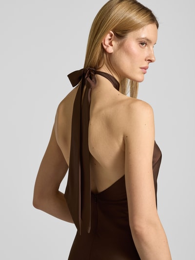 Frauenmodel trägt Abendkleid mit Neckholder zum Binden von Mascara aus braunem Satin mit Rückenausschnitt, körpernahe Passform, Nahaufnahme Oberkörper.