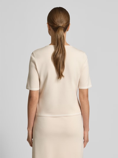 Frauenmodel trägt Strickpullover mit Rundhalsausschnitt von Marc Cain im Viskose-Mix in Creme, lockerer Schnitt, Ganzkörperansicht Rückansicht.