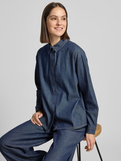 Kobieta modelka nosi Regular Fit Jeanshemd mit Hemdblusenkragen Modell 'ARCHER' od ICHI, czysta bawełna, guziki, kolor ciemnoniebieski denim, długość tyłu 62 cm w rozmiarze 36, długość rękawa 56 cm w rozmiarze 36, zdjęcie w półzbliżeniu górnej części ciała.