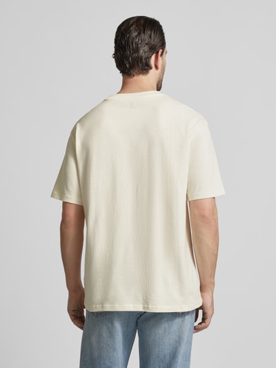 Männermodel trägt Relaxed Fit T-Shirt aus Bio-Baumwoll-Mix Modell 'MAARKOS' von Armedangels, unifarben, Ganzkörperansicht Rückansicht.