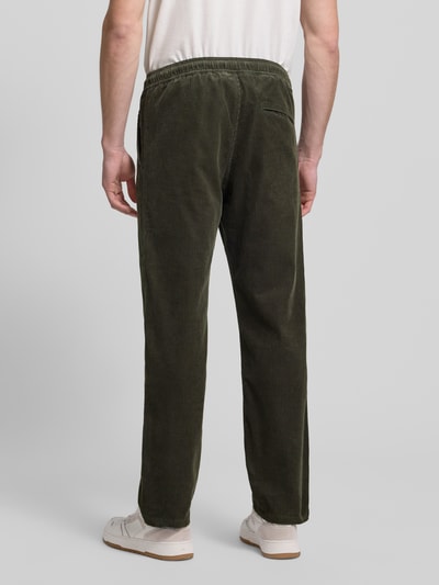 Männermodel trägt grüne Cordhose mit elastischem Bund Modell 'JABARI' von Samsøe Samsøe, Regular-Fit, Gesäßtasche, Ganzkörperansicht Rückansicht
