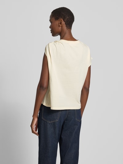 Frauenmodel trägt T-Shirt im One-Shoulder-Look Modell 'ALLIA' von Bash in Creme, reine Baumwolle, Regular Fit, Rückansicht, Ganzkörperansicht.