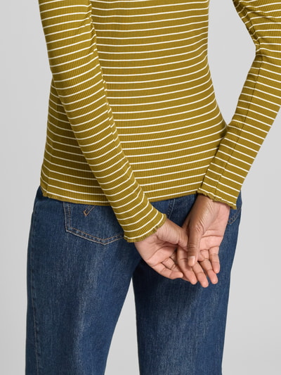 Frauenmodel trägt Slim Fit Langarmshirt aus Baumwoll-Mix Modell 'ANNA' von Selected in Gelb mit weißen Streifen, grobe Struktur, Nahaufnahme Oberkörper, Damen Langarmshirt von Selected.