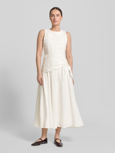 Frauenmodel trägt Midikleid aus Viskose-Mix mit Spitzenbesatz von Mango in Creme, Taillierte Passform, Rundhalsausschnitt, Ärmelloses-Design, glatte Textur, Rückenlänge 126 cm, Brustweite 44 cm, Ganzkörperansicht von vorne.