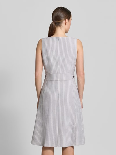 Vrouwenmodel draagt Knielanges Kleid aus Seersucker mit Streifen und Lurex van Christian Berg Woman Selection, grijs-wit met streepmotief, model in a-lijn, gestreepte look met lurexgaren en ronde hals, ruglengte 100 cm bij maat 36, borstwijdte 45 cm, knielengte, ganzkörperansicht rückansicht.