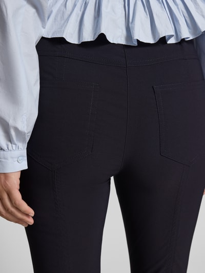Frauenmodel trägt Caprihose aus Viskose-Mix Modell 'Igor3' von STEHMANN in Schwarz, Slim Fit mit elastischem Bund, Detailaufnahme Rückansicht.