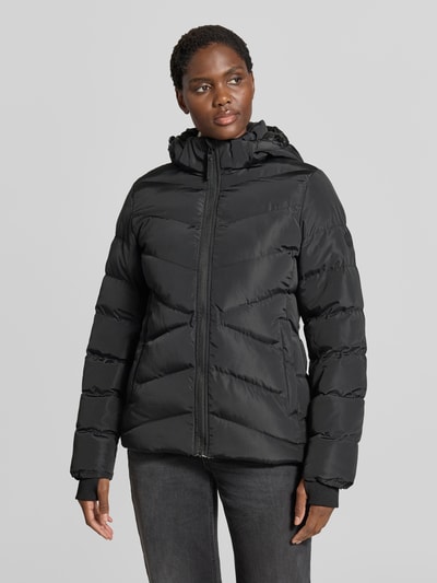 Frauenmodel trägt Regular Fit kurtka z efektem pikowania Model 'Synria' od Cars Jeans, kaptur ze stójką, wpuszczane kieszenie, zamek błyskawiczny, długość tyłu w rozmiarze S: 65 cm, szerokość ramion w rozmiarze S: 42 cm, szerokość w rozmiarze S: 50 cm, długość rękawów w rozmiarze S: 70 cm, czarny kolor, gładka tekstura, Ganzkörperansicht von vorne.