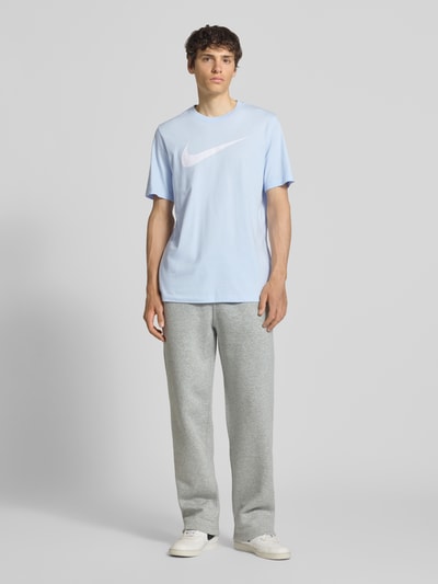 Männermodel trägt Herren T-Shirt mit Logo-Print Modell 'Swoosh' von Nike aus Reine Baumwolle, Gerader-Schnitt, Rundhalsausschnitt, Ganzkörperansicht von vorne.