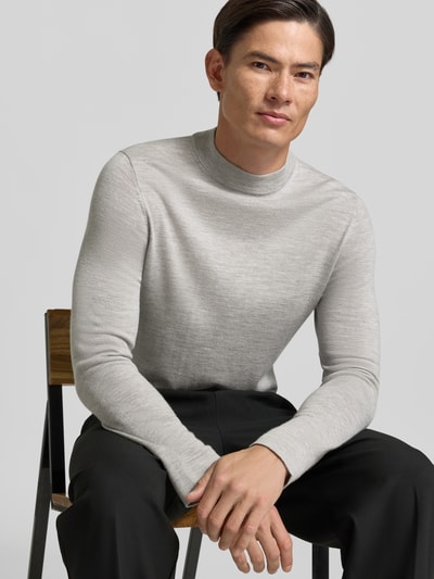 Männermodel trägt Slim Fit Longsleeve aus reiner Schurwolle Modell 'Arwon' von DRYKORN in Hellgrau, Stehkragen, Nahaufnahme Oberkörper.