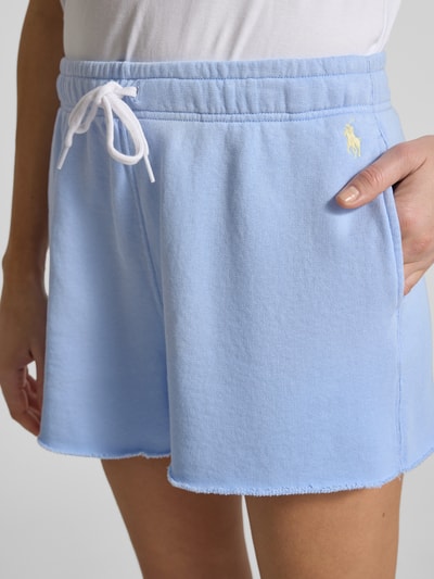 Frauenmodel trägt Regular Fit Sweatshorts aus Baumwoll-Mix von Polo Ralph Lauren, Optik: Unifarben, hellblau, Logo-Stitching, Eingrifftaschen, Bundabschluss: Elastisch mit Tunnelzug, Materialverarbeitung: Sweat, Nahaufnahme Oberkörper.