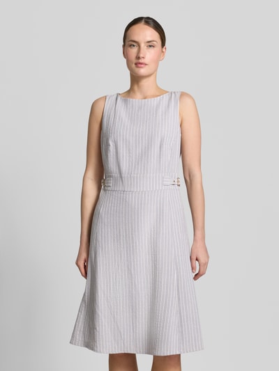 Vrouwenmodel draagt Knielanges Kleid aus Seersucker mit Streifen und Lurex van Christian Berg Woman Selection, lichtgrijze A-lijn, gestreepte look, ronde hals, seersucker textuur, knielengte, ruglengte maat 36 100 cm, borstwijdte 45 cm, Ganzkörperansicht van voren.