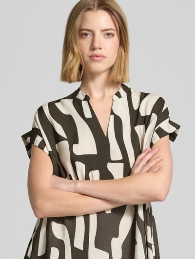 Frauenmodel trägt knielanges Kleid mit Tunikakragen Modell 'Wulana dune' von OPUS aus Viskose-Mix mit grafischem Muster, Nahaufnahme Oberkörper.