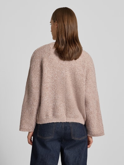 Frauenmodel trägt Strickjacke mit V-Ausschnitt Modell 'RENE' von Topshop in Beige mit Strukturmuster, Ganzkörperansicht Rückansicht.