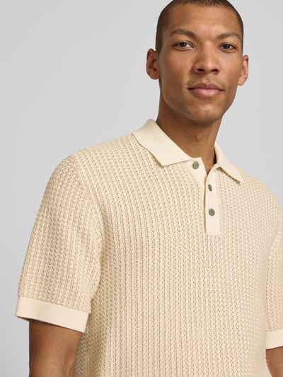 Męski model nosi Regular Fit Poloshirt in Strick-Optik Modell 'Kingsley' von Jack & Jones Premium, bawełna, krótki rękaw, kremowy, imitacja dzianiny, z kołnierzykiem polo i elastycznymi wykończeniami, długość tyłu w rozmiarze M: 77 cm, zbliżenie na górę ciała