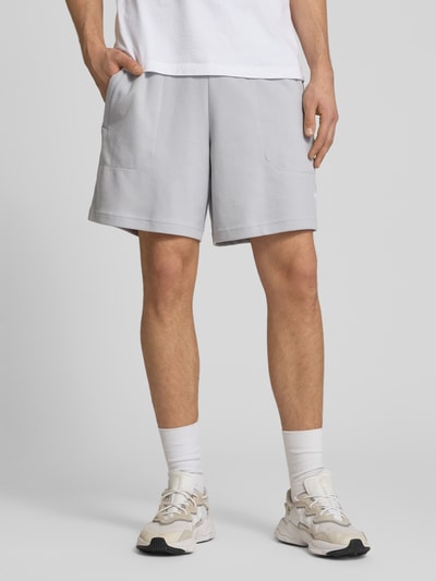 Männermodel trägt Regular Fit Sweatshorts mit Baumwoll-Anteil von adidas Originals, Optik: Unifarben, Waffelstruktur, Nahaufnahme Unterkörper.