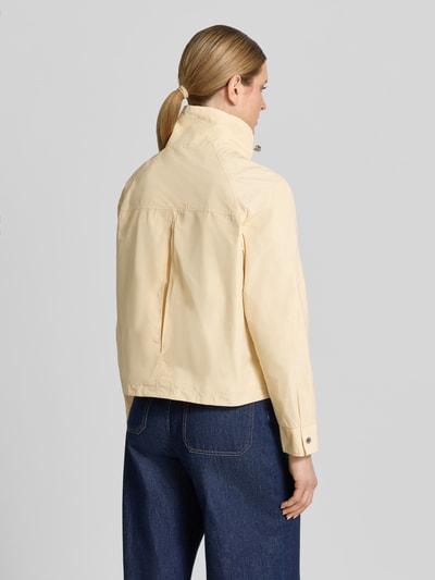 Vrouwenmodel draagt Jacke mit Stehkragen und Pattentaschen van Fuchs Schmitt in lichtgeel, regular fit, klepzakken, rugpand met split, lange mouw, ruglengte 58 cm, schouderbreedte 41 cm, borstwijdte 54 cm, mouwlengte 63 cm, volledige achteraanzicht.