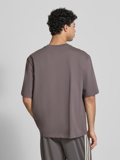 Männermodel trägt T-Shirt mit Label-Stitching von adidas Originals aus pure katoen, losse pasvorm, rechte achterkant, detailopname rugaanzicht.