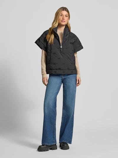 Vrouwenmodel draagt Cape met rits en steekzakken model 'NETTI' van Cph Muse in zwart, regular fit, opstaande kraag, jeans, voorkant volledige lichaamsopname.