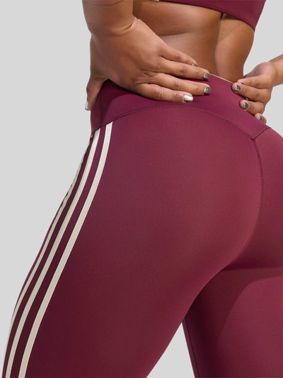 Frauenmodel trägt Slim Fit Sport-Leggings mit CLIMACOOL Technologie von adidas, glattes bordeauxfarbenes Material, Detailaufnahme, Damen Sport-Leggings von adidas Training