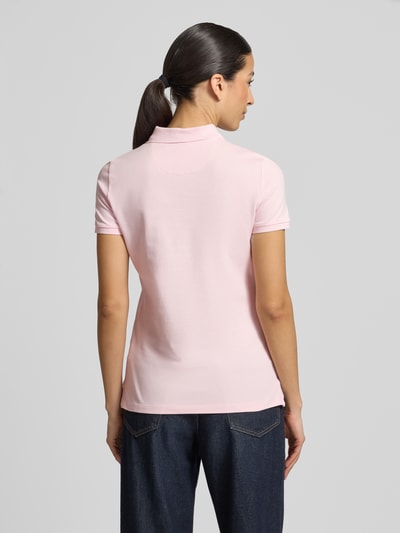Frauenmodel trägt Slim Fit Poloshirt mit Knopfleiste von Christian Berg Woman aus Baumwoll-Elasthan-Mix, hellrosa, Seitenschlitze, Rückenlänge bei Größe S 62 cm, Ganzkörperansicht Rückansicht.