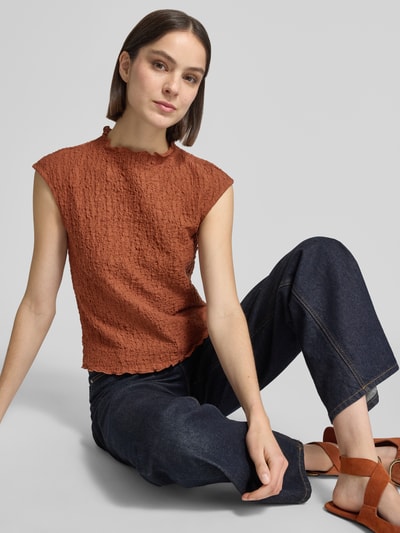 Kobiece modelka nosi Top mit Strukturmuster von Jake*s Collection, mieszanka bawełny z dodatkiem streczu, krój regular fit, stójka, długość tyłu w rozmiarze S: 53 cm, w kolorze rdzawego brązu i granatowym, fakturowana powierzchnia, pełny widok z przodu siedzącej sylwetki.