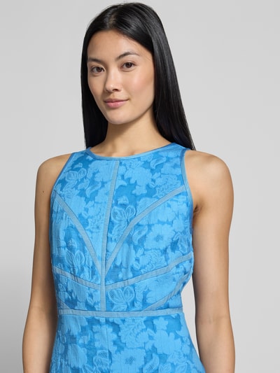 Frauenmodel trägt Midikleid aus reiner Viskose Modell 'Lee' von Ted Baker, florales Muster in Blau, ärmellos, Nahaufnahme Oberkörper.