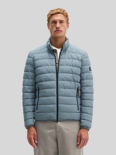 Männermodel trägt Regular Fit Steppjacke mit Zweiwege-Reißverschluss von Marc O'Polo in Hellblau, glatte Oberfläche, Ganzkörperansicht von vorne.