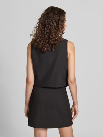 Frauenmodel trägt schwarze Regular Fit Anzugweste mit Viskose-Anteil Modell 'BOSELLA' von PIECES, glatte Struktur, Ganzkörperansicht Rückansicht.
