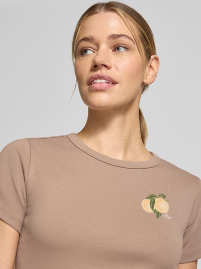 Vrouwenmodel draagt Regular Fit T-Shirt uit katoenmix model 'DELORIS_4' van HUGO, effen beige met perzik en labelprint, jersey, halslijn rond, korte mouw, Nahaufnahme bovenlichaam.