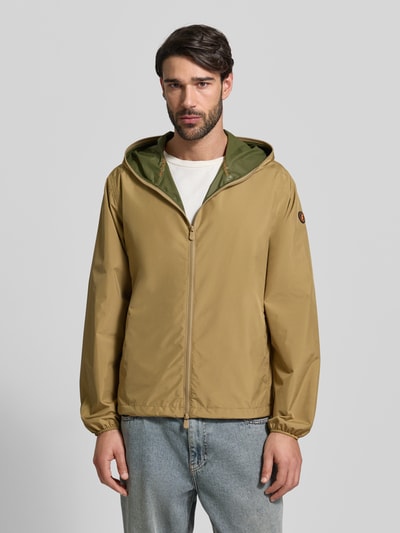 Männermodel trägt Jacke mit Zweiwegereißverschluss Modell 'Zayn' von SAVE THE DUCK in Beige, Regular Fit, Kapuze, Ganzkörperansicht von vorne.