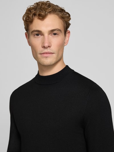 Männermodel trägt schwarzen Slim Fit Longsleeve aus reiner Schurwolle Modell 'Arwon' von DRYKORN, feine Struktur, Nahaufnahme Oberkörper