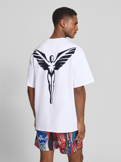Männermodel trägt weißes Relaxed Fit T-Shirt mit Logo-Stitching Modell 'Ikarus' von COLUCCI aus Baumwolle, Ganzkörperansicht Rückansicht.