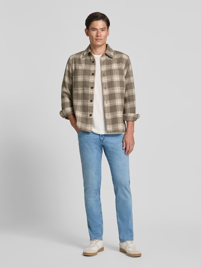 Männermodel trägt Straight Fit Jeans aus Baumwoll-Mix von bugatti in Hellblau, 5-Pocket-Design, Ganzkörperansicht von vorne.