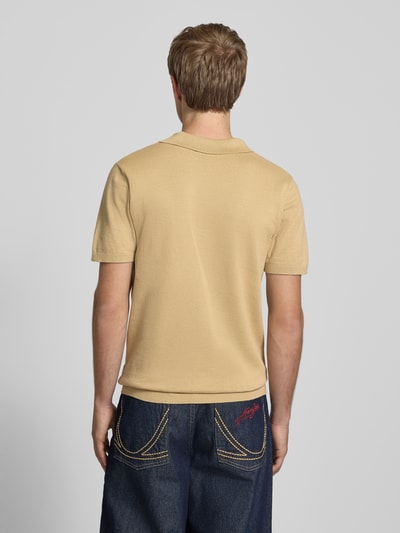 Männermodel trägt Regular Fit Poloshirt in Strick-Optik Modell 'Bray' von Blend, beige, reine Baumwolle, kurzärmelig, Ganzkörperansicht Rückansicht.