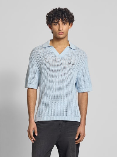 Männermodel trägt Slim Fit Poloshirt in Crochet-Optik von REVIEW in Hellblau, reine Baumwolle, Polokragen, Halbarm, Logo-Stitching, Ganzkörperansicht von vorne