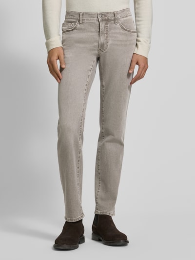 Männermodel trägt Slim Fit Jeans mit 5-Pocket-Design Modell 'Chuck' von Brax, Baumwoll-Elasthan-Mix, helles Beige, Ganzkörperansicht von vorne. Bundweite 42 cm, Innenbeinlänge 79 cm, Knopf- und Reißverschluss.
