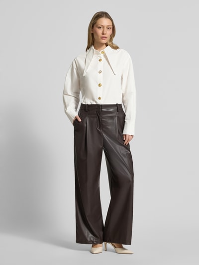 Frauenmodel trägt Oversized Hemdbluse aus reiner Baumwolle Modell 'JOMATO' von Essentiel Antwerp, Weiß, lockere Form, goldene Knöpfe, Ganzkörperansicht von vorne