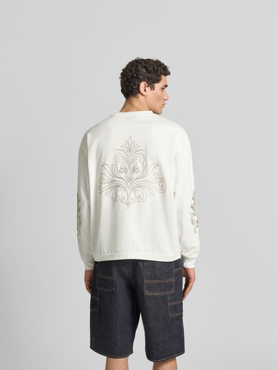 Männermodel trägt Oversized Sweatshirt aus Baumwolle von Don’t Waste Culture, Florale-Stickereien, Rückenlänge 66 cm, Ganzkörperansicht Rückansicht.