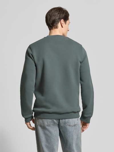 Männermodel trägt Regular Fit sweatshirt uit pure bio katoen Model 'BAARO FLEECE' van Armedangels, look: effen, logodetail, geribde mouw- en rompzoom, ronde hals, sweatmateriaal, ganzkörperansicht rückansicht.