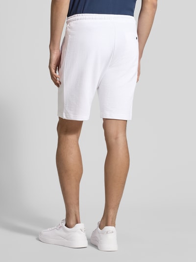 Männermodel trägt Shorts mit elastischem Bund von Christian Berg Men aus Baumwoll-Elasthan-Mix, Regular-Fit, Eingrifftaschen, Tunnelzug, Ganzkörperansicht Rückansicht.