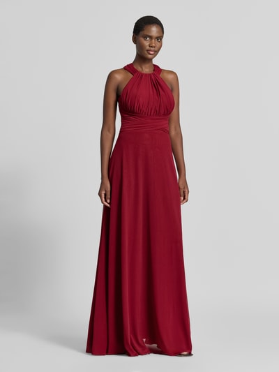 Modelka nosi Abendkleid mit Neckholder und Raffungen von TROYDEN COLLECTION, czerwony szyfon, krój slim fit, długie, marszczony dekolt, zamek z tyłu, długość pleców w rozmiarze 36: 167 cm, szerokość w rozmiarze 36: 28 cm, zdjęcie całej sylwetki z przodu.