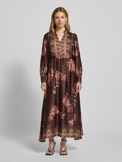 Frauenmodel trägt Maxikleid aus Satin mit Bindegürtel von Neo Noir, floraler Print in Rosatönen, A-Linie, V-Ausschnitt, Knopfleiste, Ganzkörperansicht von vorne.